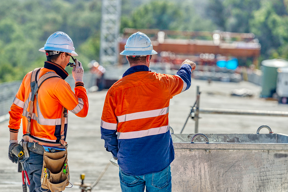 case civil and structural engineering engineers wearing protective hard hat and hi vis on site temporary works project of bolivia hill bridge under construction