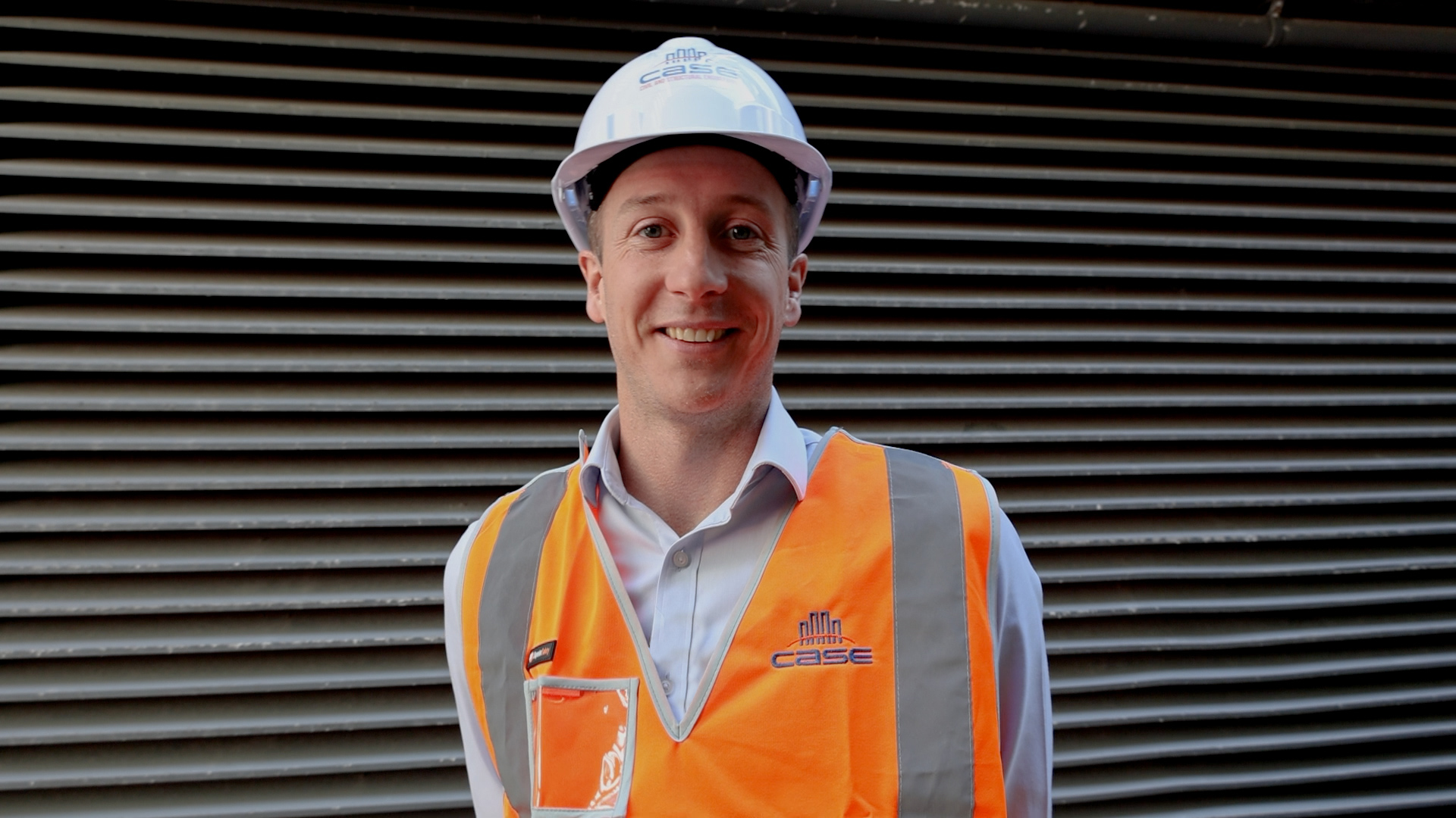 a portrait of civil engineer anthony mclellan wearing protective hard hat and hi vis vest