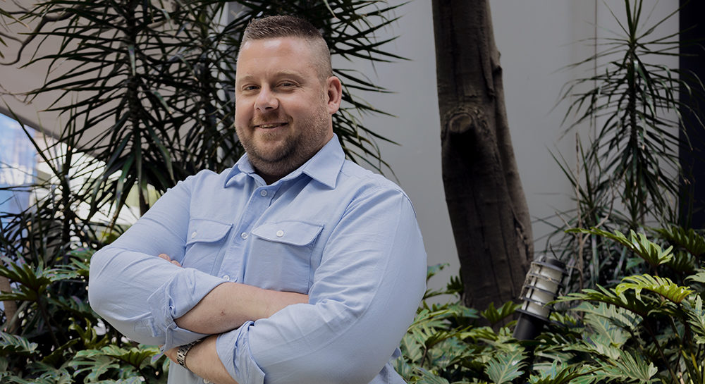 a corporate headshot portrait of civil structural design man engineer paul szubert in front of trees